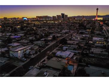 Aerial view of home with pool, showcasing Las Vegas skyline in background at 1625 Phillips Ave, Las Vegas, NV 89104