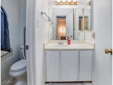 Bright bathroom featuring a white vanity, ample storage, and a mirrored medicine cabinet at 4614 Grand Dr # 1, Las Vegas, NV 89169