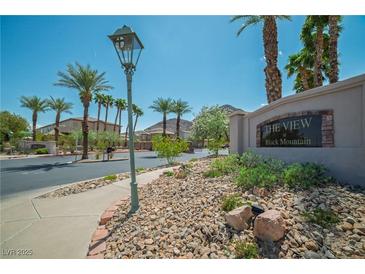 Community entrance with palm trees, lush landscaping, and clear blue skies on a sunny day at 716 Solitude Point Ave, Henderson, NV 89012