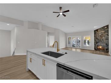 Modern kitchen with white cabinets, quartz countertops, and gold hardware at 5404 Harmony Green Dr # 201, Las Vegas, NV 89149