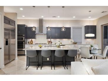 Modern kitchen featuring gray cabinets, stainless steel appliances, pendant lighting, and a spacious island with bar seating at 2781 Josephine Dr, Henderson, NV 89044