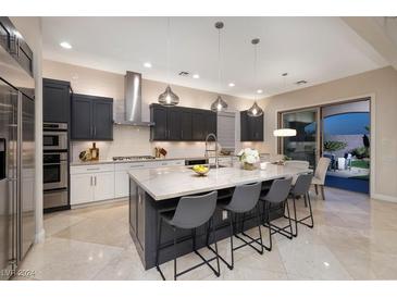 A modern kitchen features an island with barstool seating and stainless steel appliances at 2781 Josephine Dr, Henderson, NV 89044