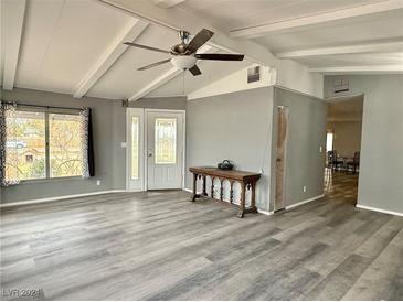 Inviting living room features light gray walls, wood-look floors, ceiling fan, and a decorative console table at 2510 N Woodchips Rd, Pahrump, NV 89060