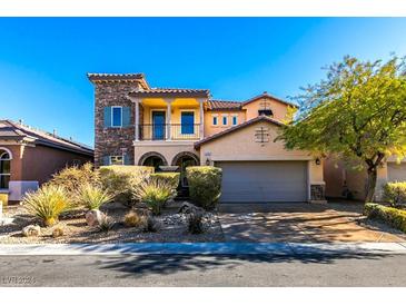 Charming two-story home with stone accents, balcony, desert landscaping, and a two-car garage at 10292 Kalang St, Las Vegas, NV 89178