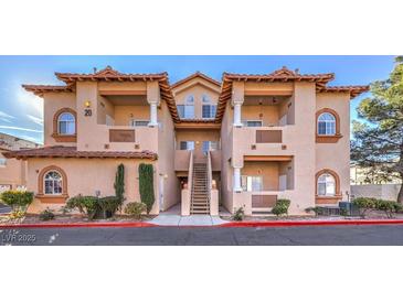 Two-story stucco building with Spanish-style architecture, balconies, and lush landscaping at 2925 Wigwam Pkwy # 2021, Henderson, NV 89074