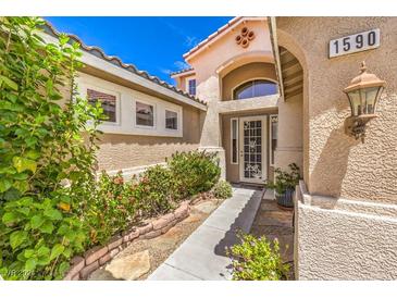 Inviting front entrance with landscaped walkway and well-maintained stucco exterior details at 1590 Sabatini Dr, Henderson, NV 89052