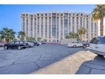 Spacious parking area near a modern high-rise building, complemented by palm trees at 3930 University Center Dr # 1003, Las Vegas, NV 89119