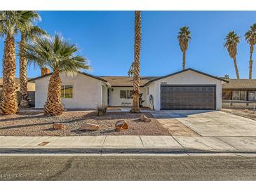 Remodeled single-story home with a landscaped front yard and new garage door at 3698 Rawhide Ct, Las Vegas, NV 89120