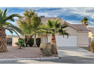 One-story house with a white garage door and desert landscaping at 1565 Pasture Ln, Las Vegas, NV 89110