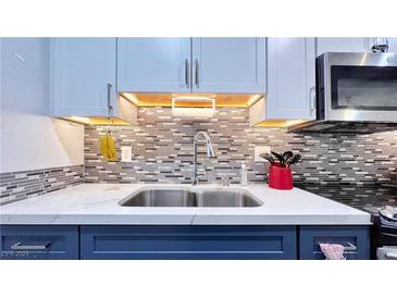 Modern kitchen with stainless steel appliances and stylish blue cabinets at 4950 Larkspur St, Las Vegas, NV 89120