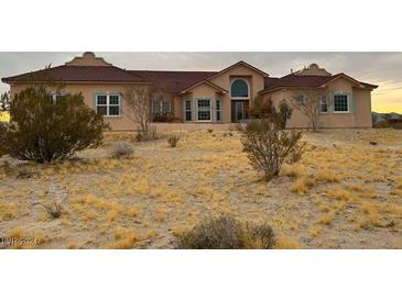 One-story house with a red tile roof and desert landscaping at 2225 Paiute St, Jean, NV 89019