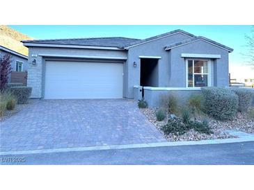 Single-story home with gray exterior, two-car garage, and landscaped front yard at 32 Honeymoon Dr, Henderson, NV 89011