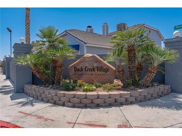 Attractive Duck Creek Village signage surrounded by landscaping and palm trees at community entrance at 5409 Centurion Ct # 104, Las Vegas, NV 89122