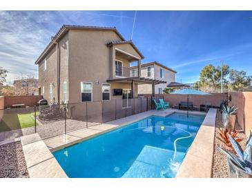 A pristine in-ground pool is fenced in for safety, with outdoor seating and a balcony feature at 6482 Twin Harbors Ct, Las Vegas, NV 89141