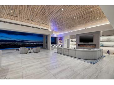 Expansive living room featuring a modern fireplace and city views at 673 Falcon Cliff Ct, Henderson, NV 89012