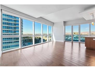 Bright living room with hardwood floors and floor-to-ceiling windows offering stunning city views at 4471 Dean Martin Dr # 801, Las Vegas, NV 89103