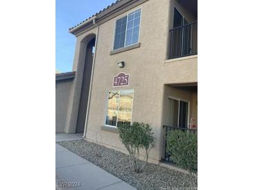 Tan two-story building with multiple windows and a walkway at 4725 Basilicata Ln # 102, North Las Vegas, NV 89084