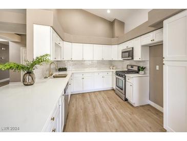 Modern kitchen with white cabinets, quartz countertops, and stainless steel appliances at 6316 W Gowan Rd, Las Vegas, NV 89108