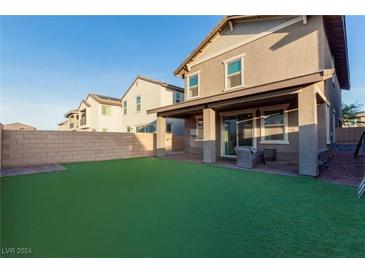 Spacious backyard with artificial turf and partial view of the house at 361 Andy Wheeler Dr, Henderson, NV 89011