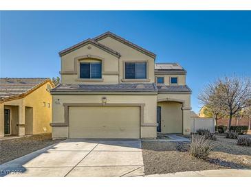 Two-story house with beige exterior, two-car garage, and landscaped yard at 6547 Velvet Silk St, North Las Vegas, NV 89084