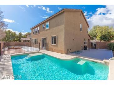 Inviting backyard pool with tanning ledge, surrounded by patio and partial fencing at 6616 Sea Swallow St, North Las Vegas, NV 89084