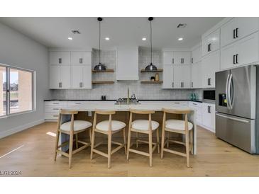 Modern kitchen with white cabinets, marble countertops, and island at 8713 Litchfield Ave, Las Vegas, NV 89134