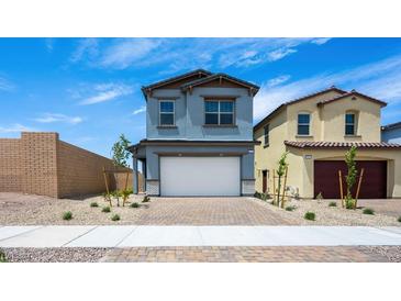 Charming two-story home with a two-car garage, brick driveway, and well-maintained landscaping at 633 N Water St, Henderson, NV 89015