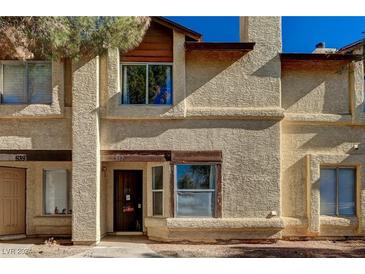 Tan stucco exterior of charming two-story home with wood accents at 537 Kristin Ln, Henderson, NV 89011