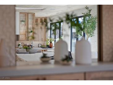 Modern kitchen featuring stainless steel appliances, light wood cabinetry, and a brick accent wall at 2401 Driftwood Dr, Las Vegas, NV 89107