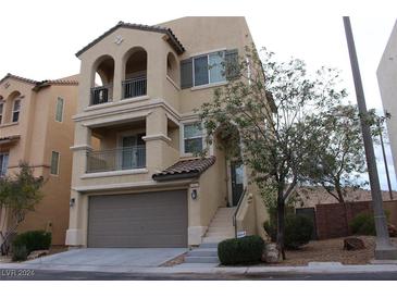 Two-story house with attached garage and balcony at 9869 Juno Hills St, Las Vegas, NV 89178