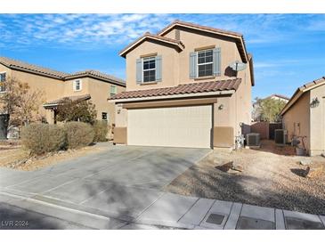 Two-story house with beige exterior, attached garage, and landscaping at 5332 Iron Crossing Ave, Las Vegas, NV 89131