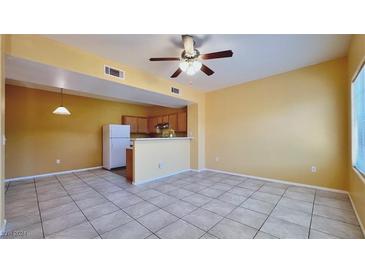 Spacious living room featuring tile flooring, a ceiling fan, and a pass-through to the kitchen at 2020 Rancho Lake Drive Dr # 205, Las Vegas, NV 89108