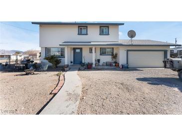 Two-story house with a gray door, attached garage, and spacious yard at 664 Spring Rd, Indian Springs, NV 89018