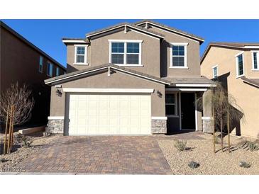 Two-story house with neutral exterior, attached garage, and landscaped front yard at 9922 Angel Valley Dr, Las Vegas, NV 89178