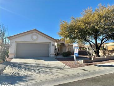 Single-story home with gray garage door and landscaped yard at 11037 Hawk Valley Ave, Las Vegas, NV 89134