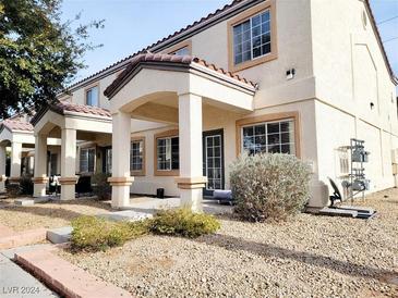 Inviting two-story home featuring a covered porch, desert landscaping, and neutral exterior paint at 5330 E Charleston Blvd # 5, Las Vegas, NV 89142