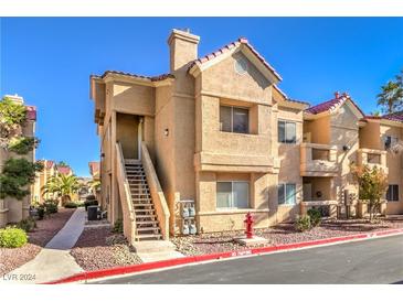 Two-story building exterior with Spanish tile roofing and landscaping at 900 Heavenly Hills Ct # 217, Las Vegas, NV 89145