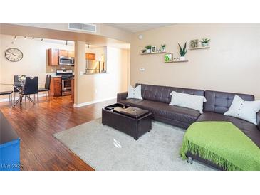Inviting living room featuring a modern leather sofa, ottoman, and decorative shelving at 2120 Ramrod Ave # 1112, Henderson, NV 89014