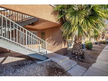 Building exterior with stairs, palm tree, and walkway at 2120 Ramrod Ave # 1112, Henderson, NV 89014