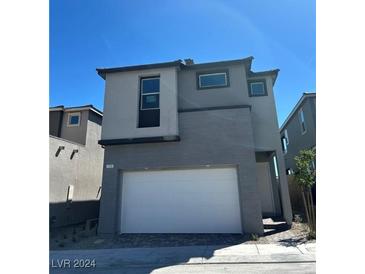 Two-story home featuring a modern design, a two-car garage, neutral paint and a well-maintained landscape at 1558 Rock Kestrel St, Las Vegas, NV 89138