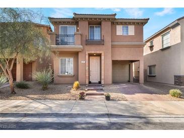 Charming two-story home with stucco exterior, small balconies, desert landscaping and brick driveway at 177 Almond Ridge Pl, Henderson, NV 89015