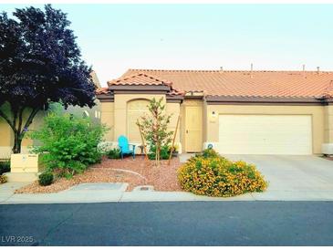 Charming single-story home featuring a well-manicured front yard and a two-car garage at 5048 Orchid Springs St, Las Vegas, NV 89148