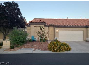 Charming single-story home with a well-maintained yard and desert landscaping, including mature trees and flowering bushes at 5048 Orchid Springs St, Las Vegas, NV 89148