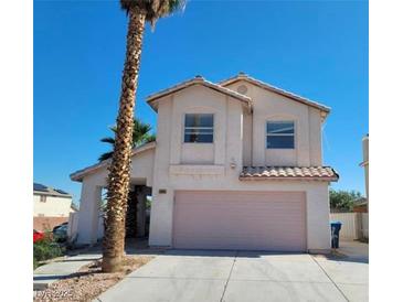 Two-story house with a pink garage door and a palm tree in the front yard at 5402 Night Swim Ln, Las Vegas, NV 89113