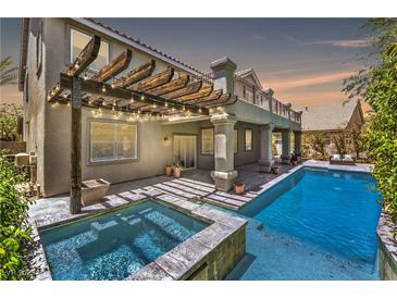 Luxury backyard oasis featuring a sparkling pool, spa, and pergola at 1516 Via Salaria Ct, Henderson, NV 89052