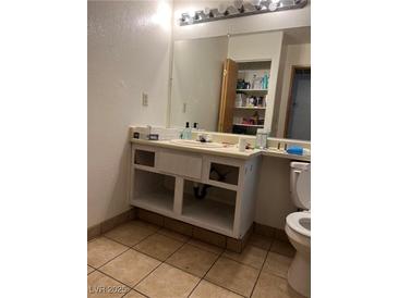 Bathroom with vanity, mirror, and toilet. Under-sink storage is partially unfinished at 2961 Juniper Hills Blvd # 102, Las Vegas, NV 89142