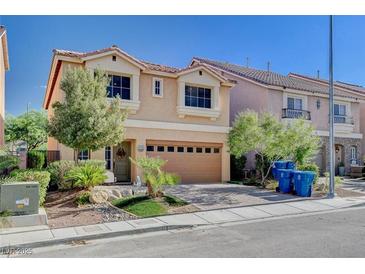 Two-story house with tan exterior, two-car garage, and landscaping at 5957 Pillar Rock Ave, Las Vegas, NV 89139