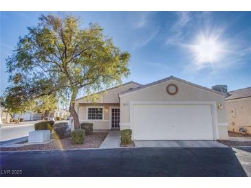 Single-story house with attached garage, landscaping, and a tree in the front yard at 5123 Mascaro Dr, Las Vegas, NV 89122