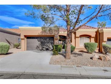 Tan one-story house with a brown door and two-car garage at 9452 Gold Mountain Dr, Las Vegas, NV 89134