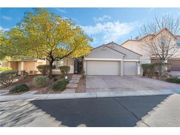 Single-story house with three-car garage, landscaped yard, and brick driveway at 10429 Loma Portal Ave, Las Vegas, NV 89166